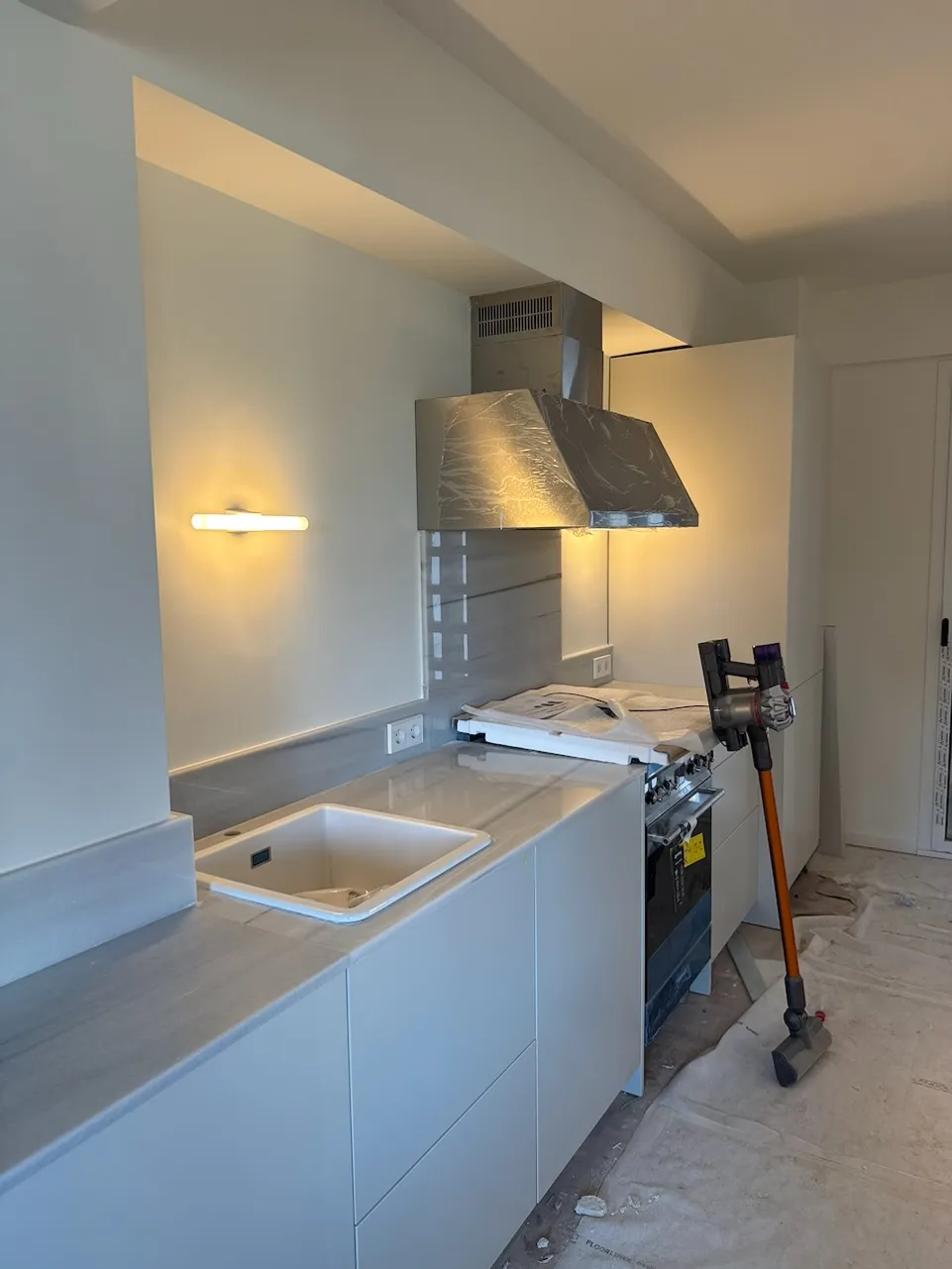A newly renovated flat kitchen in Barcelona, mid-finish with protective coverings still down.